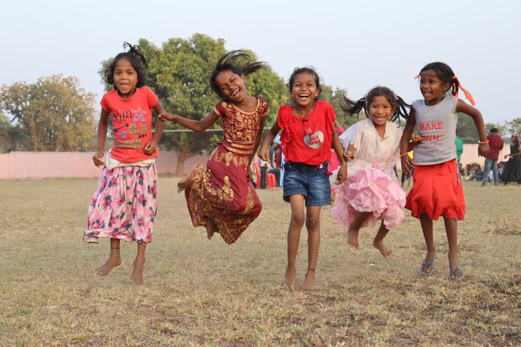 Girls skipping together in the field at one of the centres